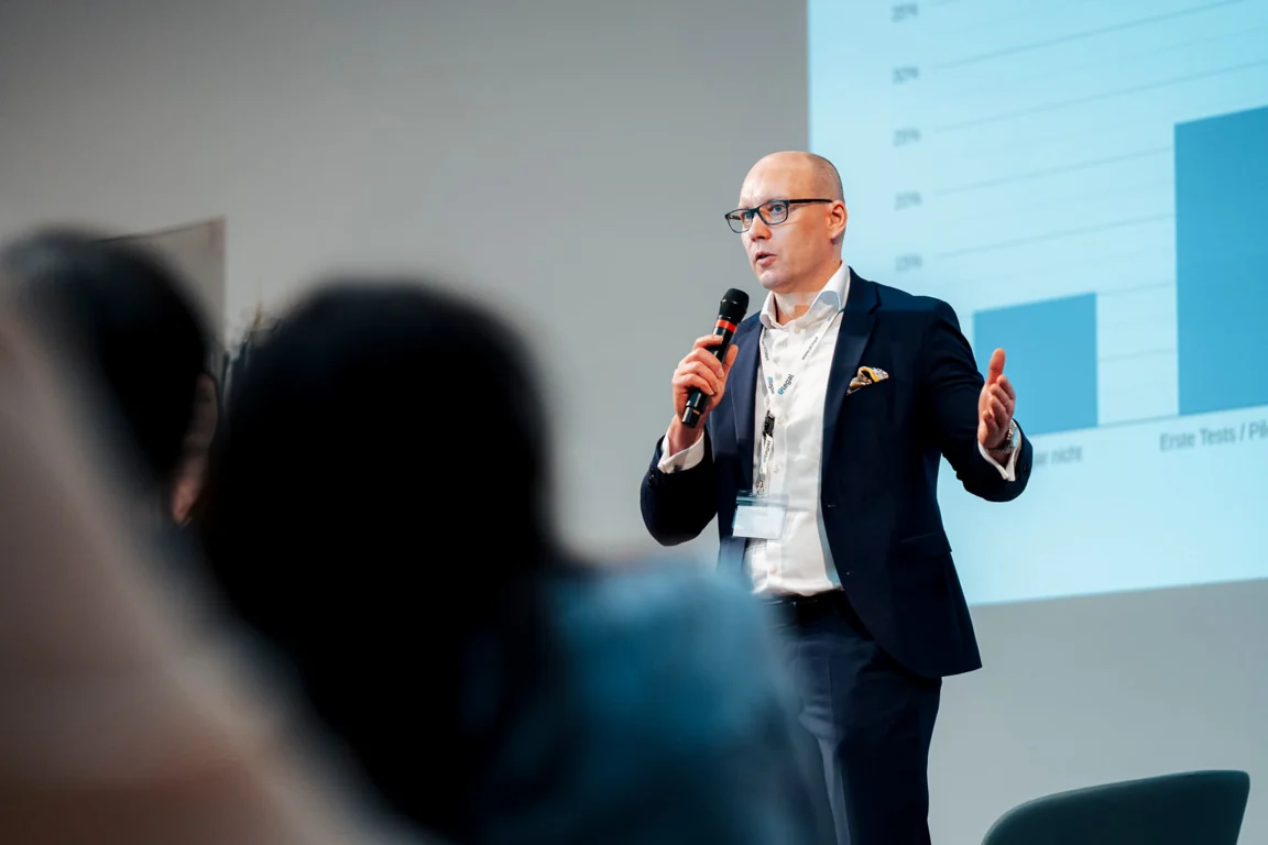 Vortrag mit Mikrofon und Präsentation vor Publikum beim KI-Lounge-Kongress am 29. Januar 2026.